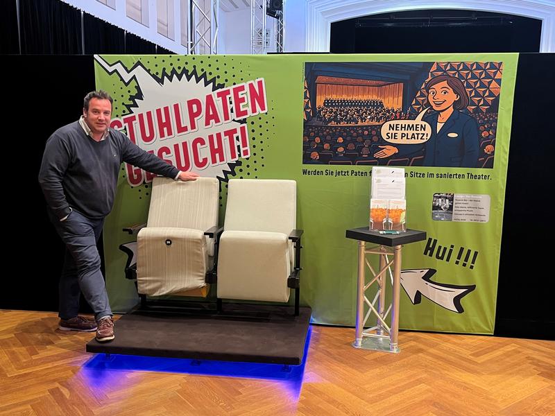 Intendant Dr. phil. Christof Wahlefeld präsentiert den neuen und im Vergleich dazu den alten Stuhl im Theater im Gemeindehaus