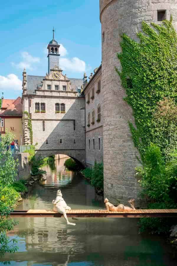 "Der Froschkönig und die Afrikanerin" des Bildhauers Peter Lenk, bei ARTBREIT 2018 über dem Breitbach, neben dem Marktbreiter Rathaus neu arrangiert 