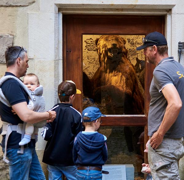 Große und kleine Besucherinnen und Besucher im ehemaligen Bärenzwinger der Veste