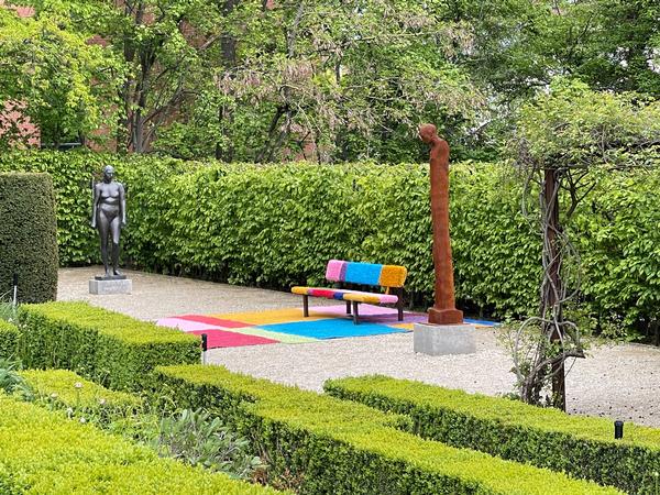 Barbara Engelhards bunte Bank "A colourful space – for you and me" (2024) zwischen Wilhelm Uhligs Skulptur "Ulla" und Michaela Biets "Stele" im Schlossgarten