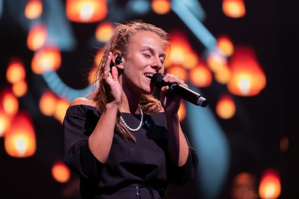 Rund 80 Musikerinnen und Musiker stehen gemeinsam auf der Bühne